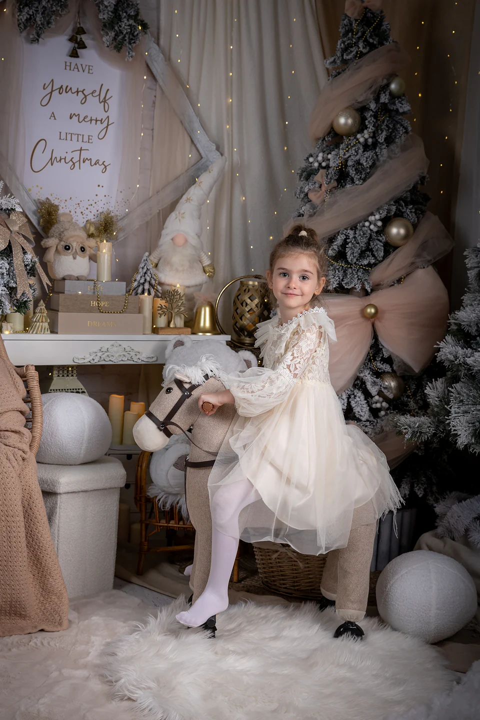 Fetiță în rochiță ivoire pe călușel, sub inscripția „Have yourself a merry little Christmas” — ședință foto de Crăciun Oradea