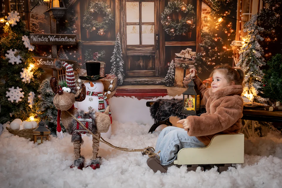 Fetiță zâmbind în săniuță, cu un felinar aprins, în decorul Santa’s Village — ședință foto de Crăciun în Bihor