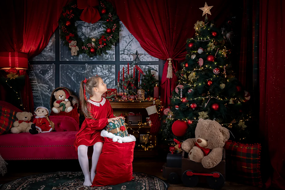 Decorul de Crăciun roșu clasic complet: brad împodobit, coroniță, ursuleți și fetiță cu sacul de cadouri — studio foto Oradea