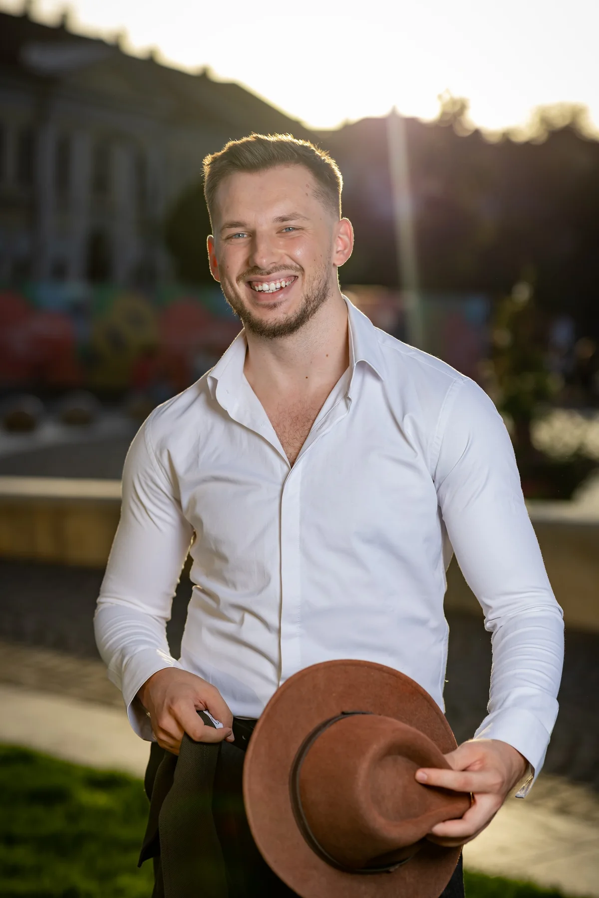 Portret zâmbind în cămașă albă, cu pălăria în mână — ședință foto în centrul Oradiei