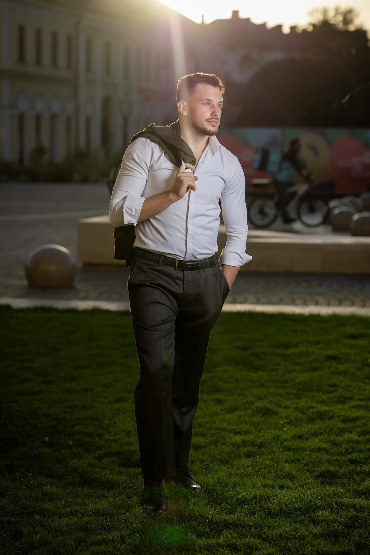Portret în picioare, cu sacoul pe umăr și lumină din spate — ședință foto în centrul Oradiei