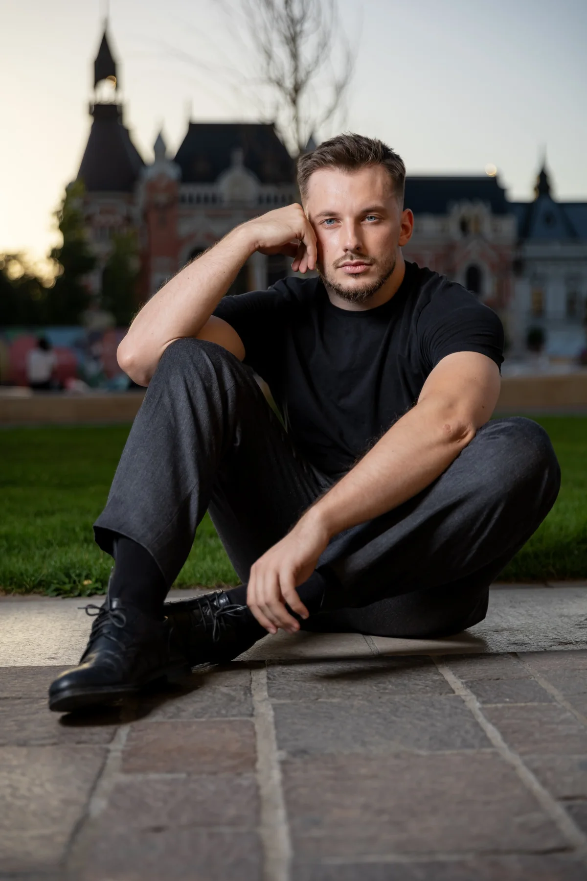 Portret așezat pe trepte, cu clădiri istorice în fundal — ședință foto în centrul Oradiei