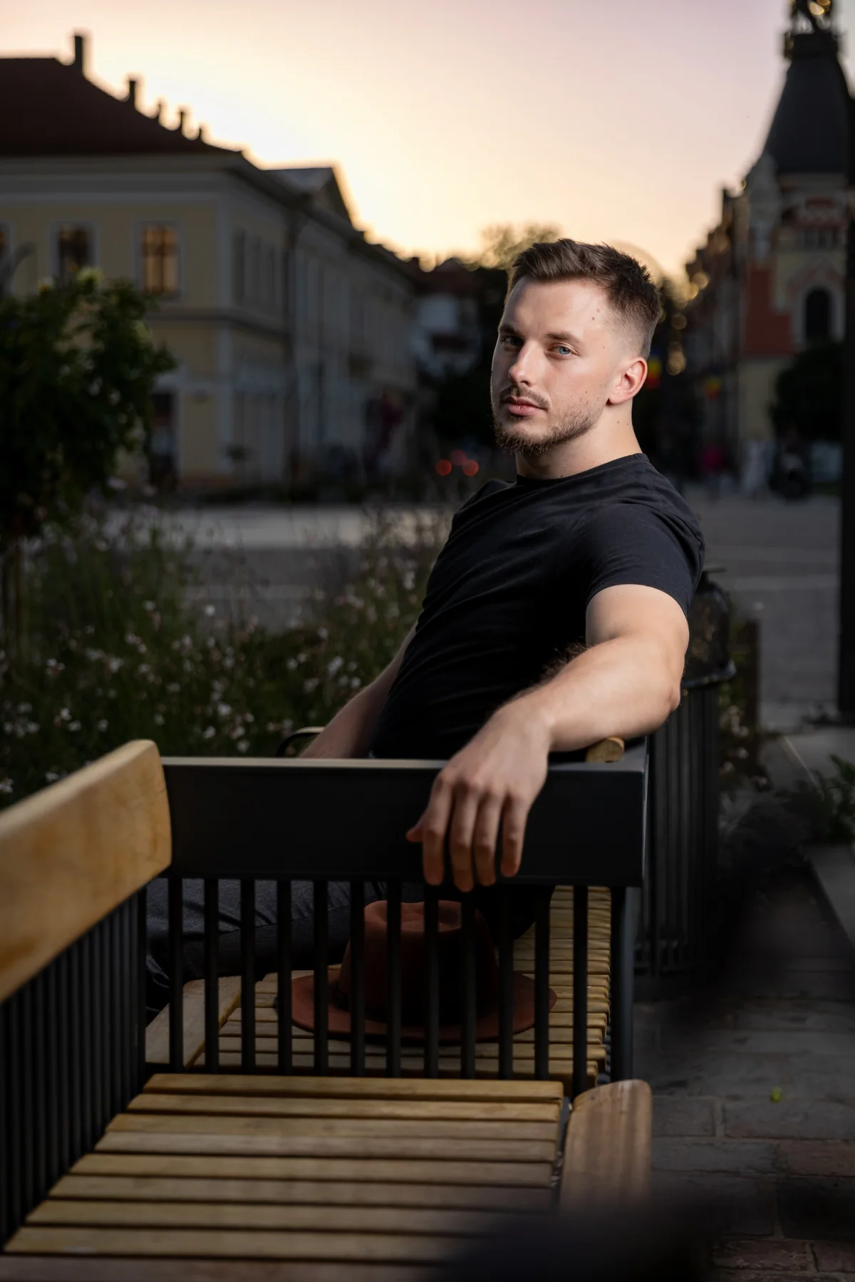 Portret pe o bancă, cu piața și clădirile în fundal — ședință foto în centrul Oradiei