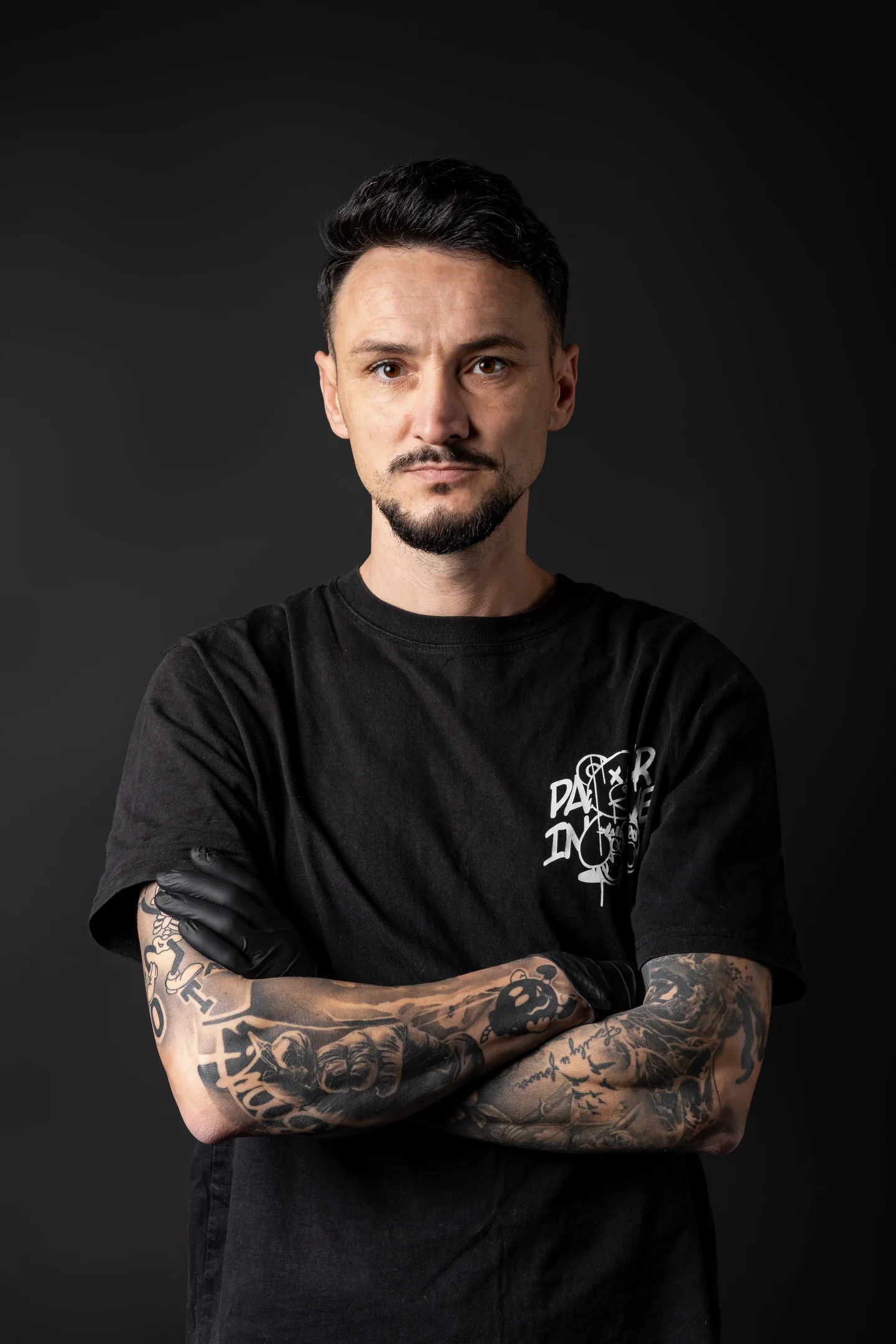 Portret în tricou negru, cu brațele tatuate încrucișate — fotografie business în Oradea