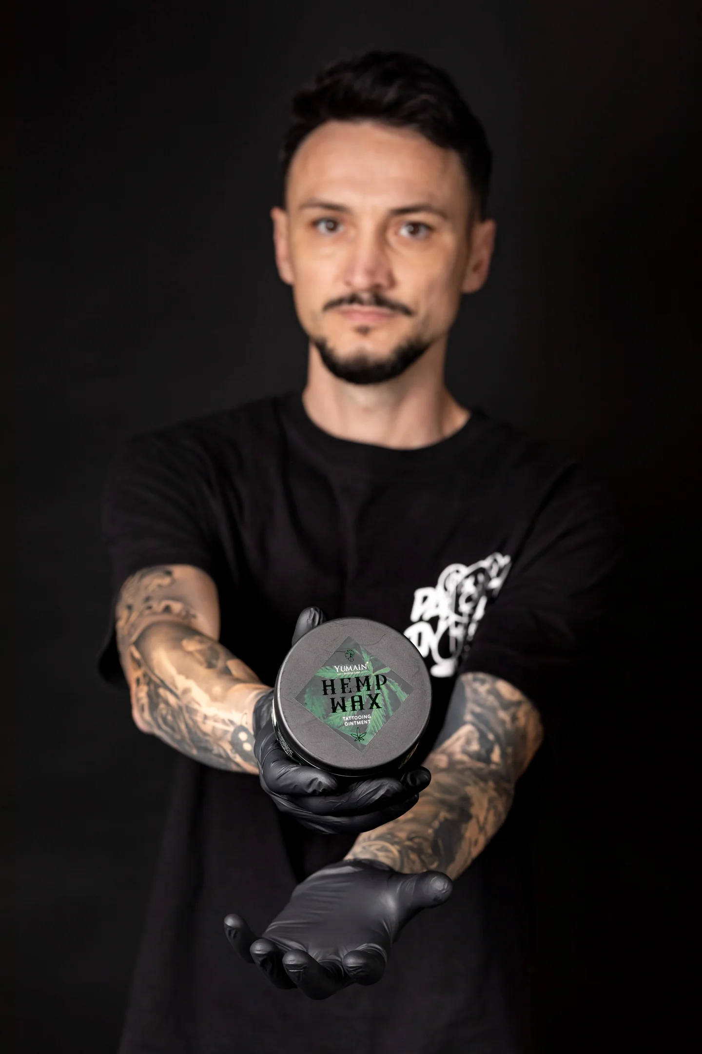 Portret cu mănuși negre, prezentând un recipient spre cameră — fotografie business în Oradea