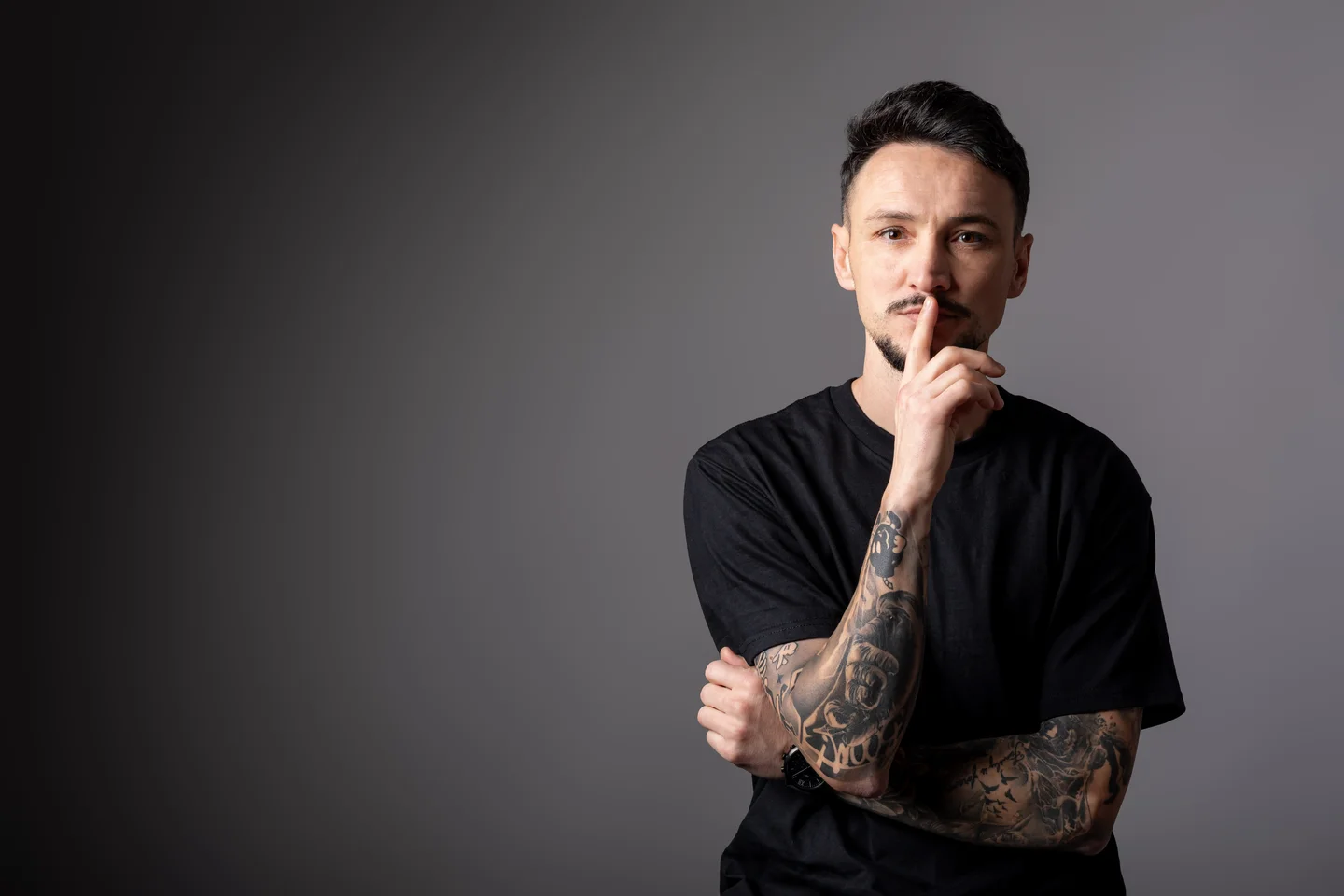 Portret orizontal în tricou negru, cu mâinile lângă bărbie — fotografie business în Oradea