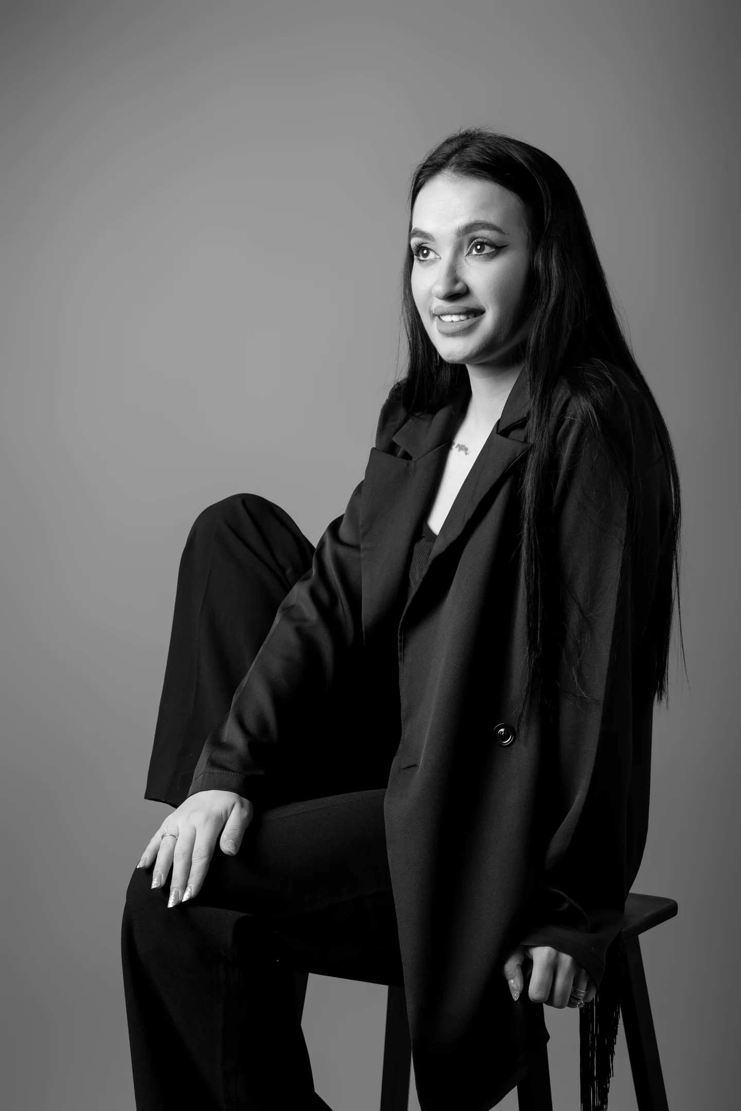 Portret alb-negru în sacou, așezată pe un scaun — fotografie business în Oradea