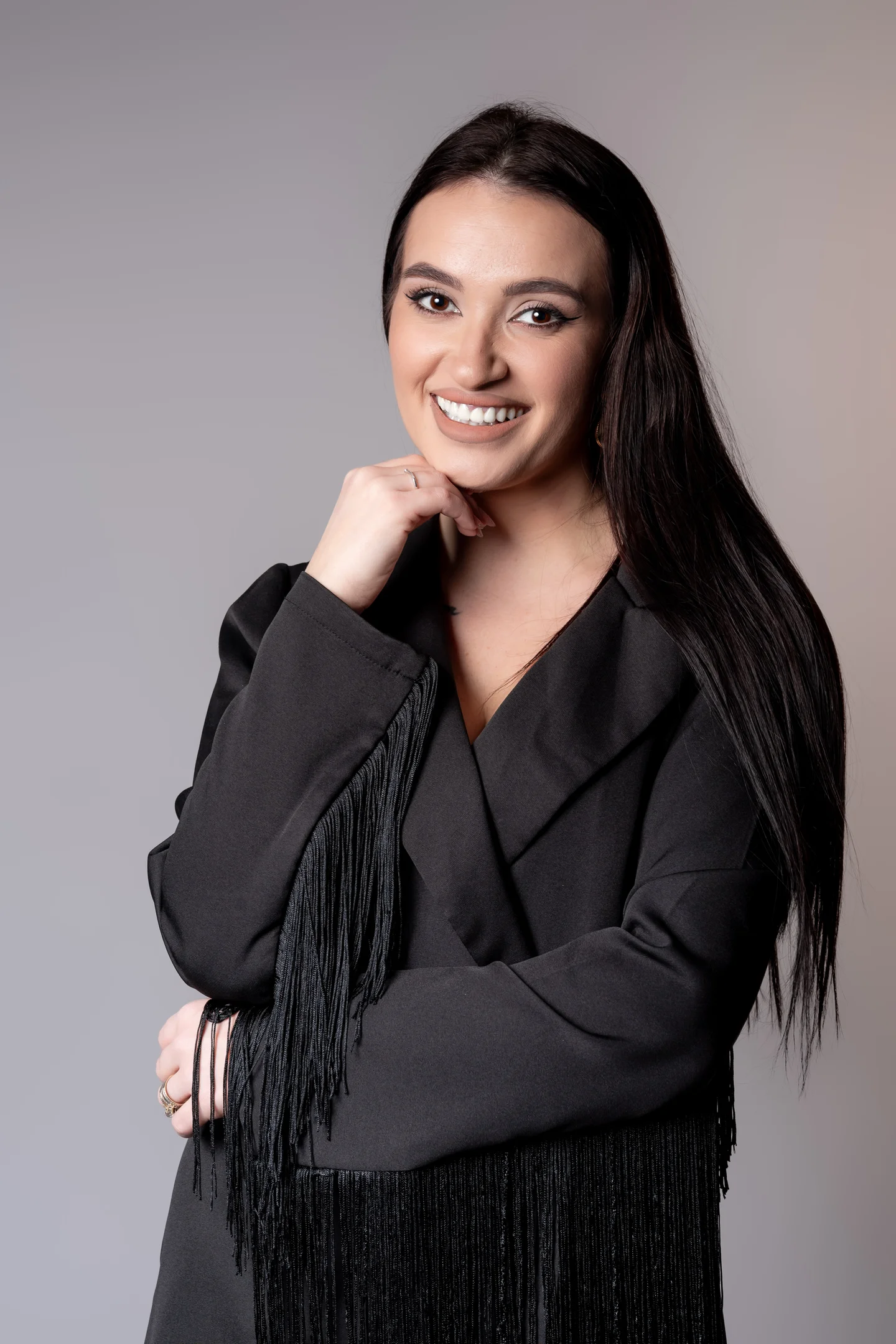 Portret zâmbind în sacou negru, pe fundal gri — fotografie business în Oradea