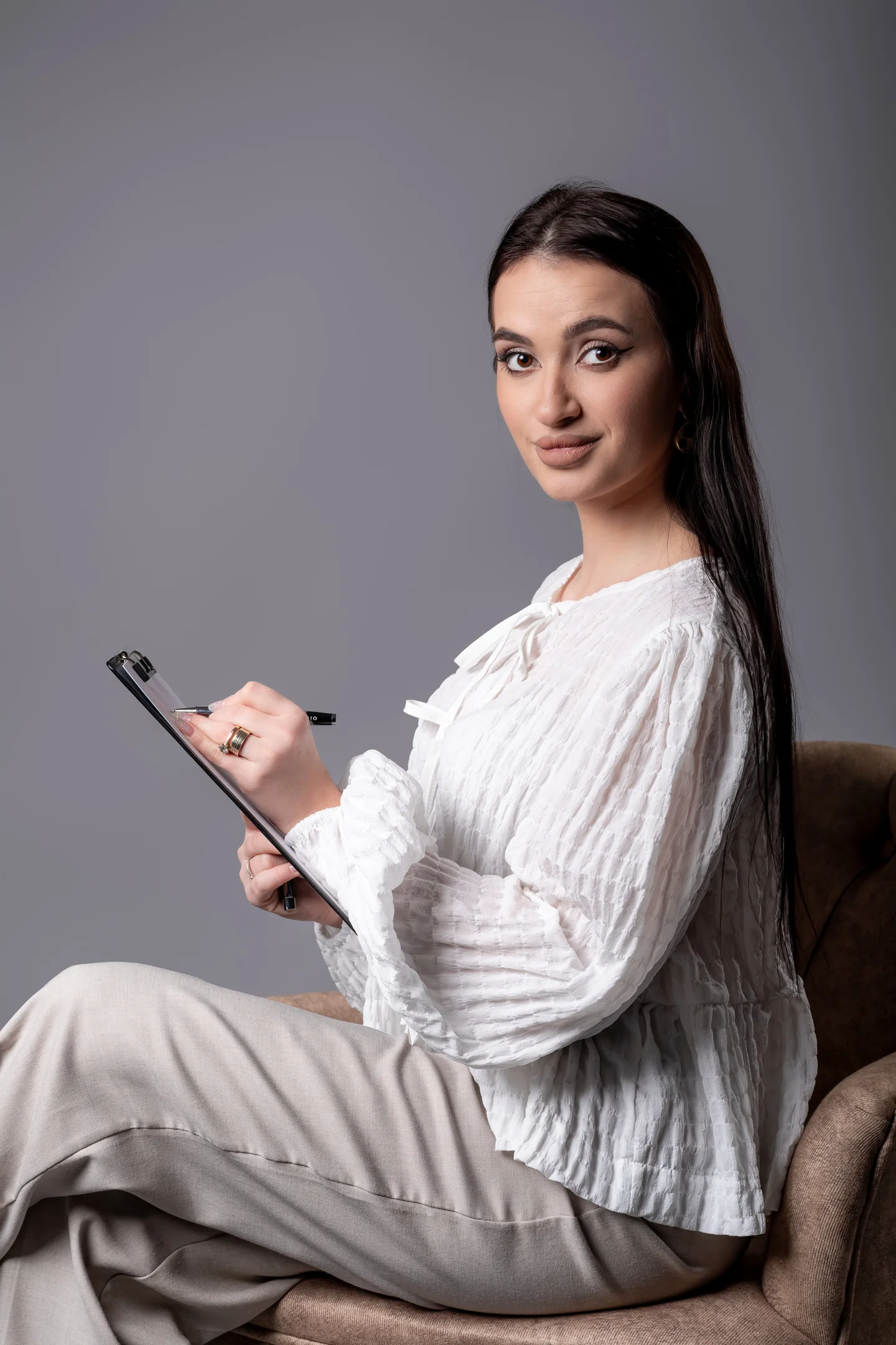 Portret cu agendă, în cămașă albă, așezată în fotoliu — fotografie business în Oradea