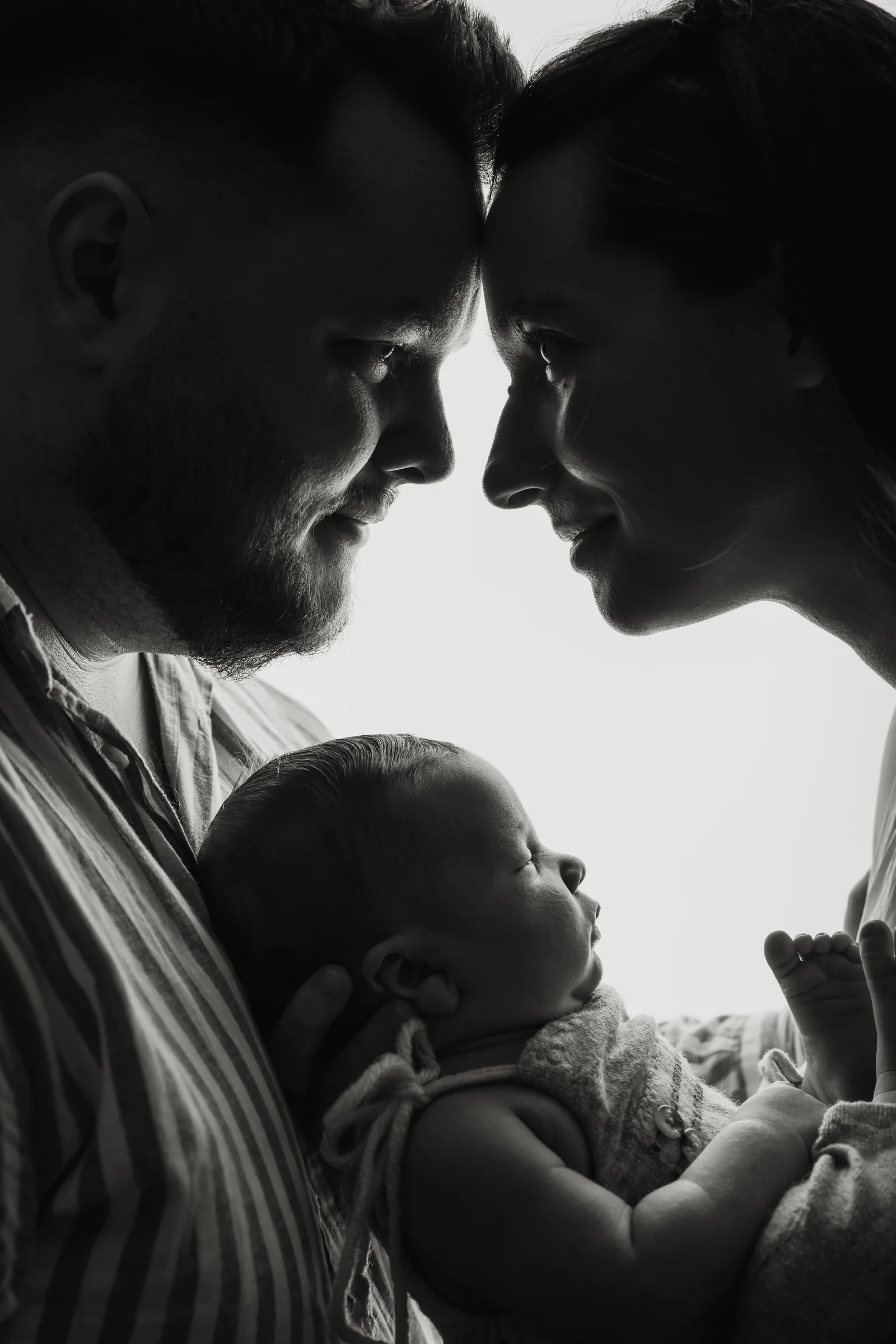 Părinți și nou-născut într-un portret alb-negru, în contralumină — fotografie de familie Oradea
