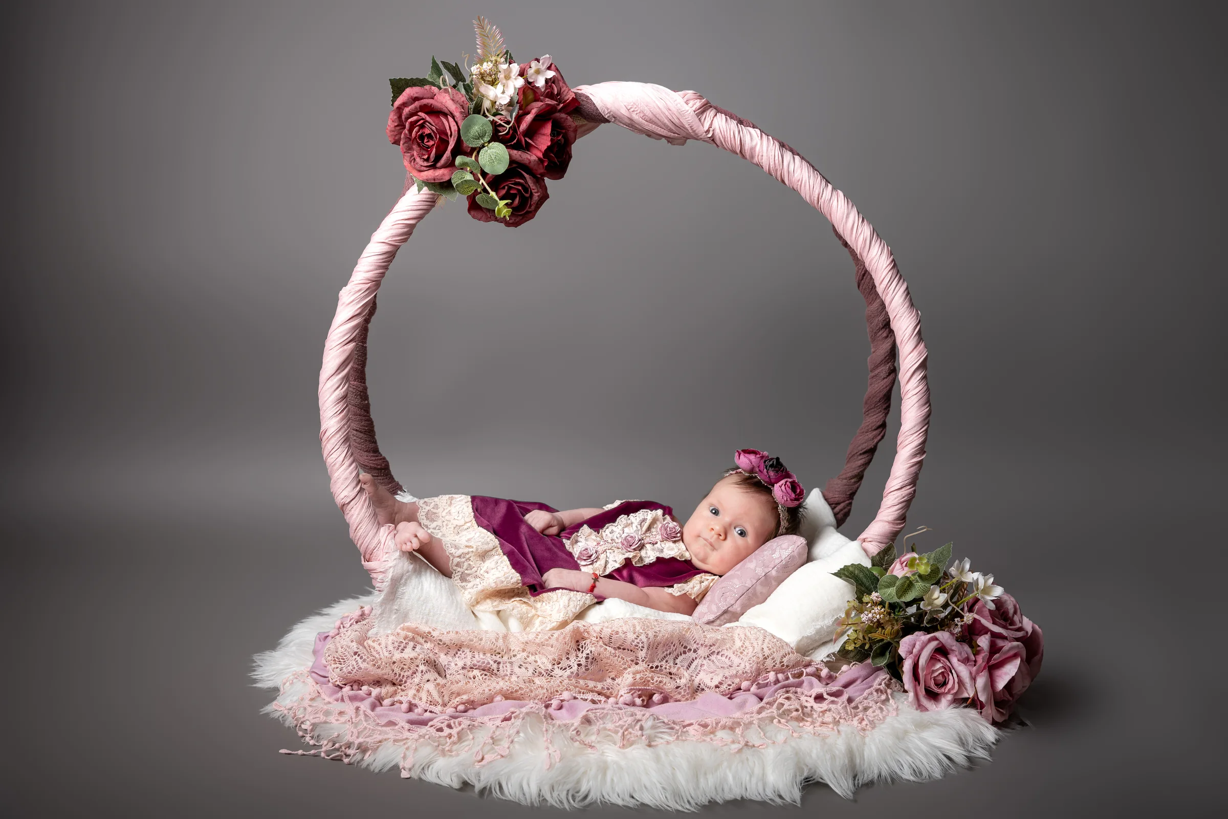Bebeluș într-un decor circular cu flori roz — ședință foto de bebeluși în Oradea