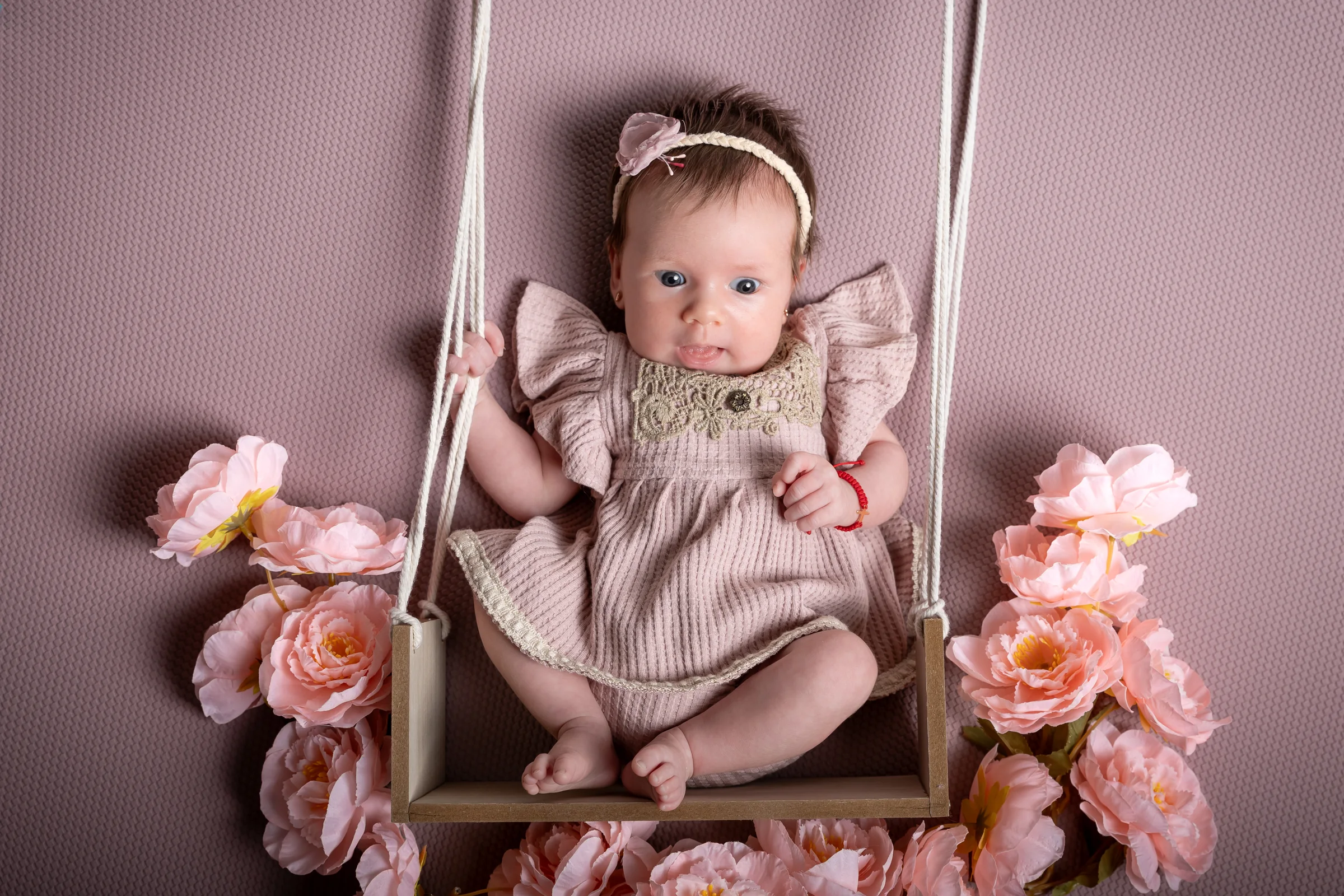 Bebeluș într-un leagăn decorat cu flori roz — ședință foto în studio Oradea